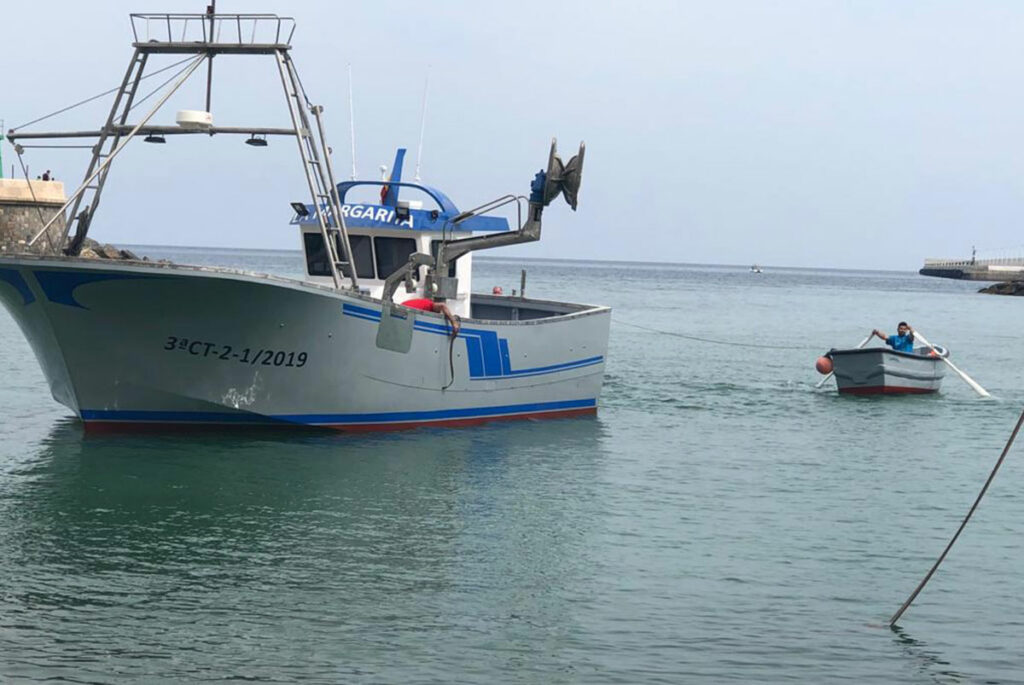 Barco de pesca La Margarita navegando por el puerto marítimo.