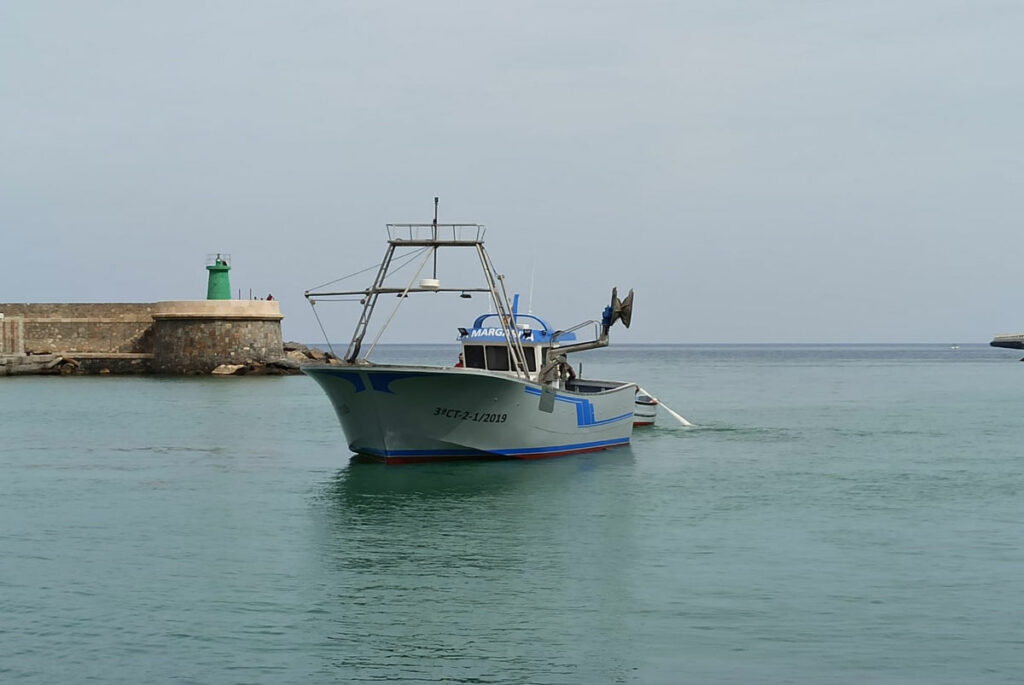 Barco de pesca La Margarita navegando por el puerto marítimo.