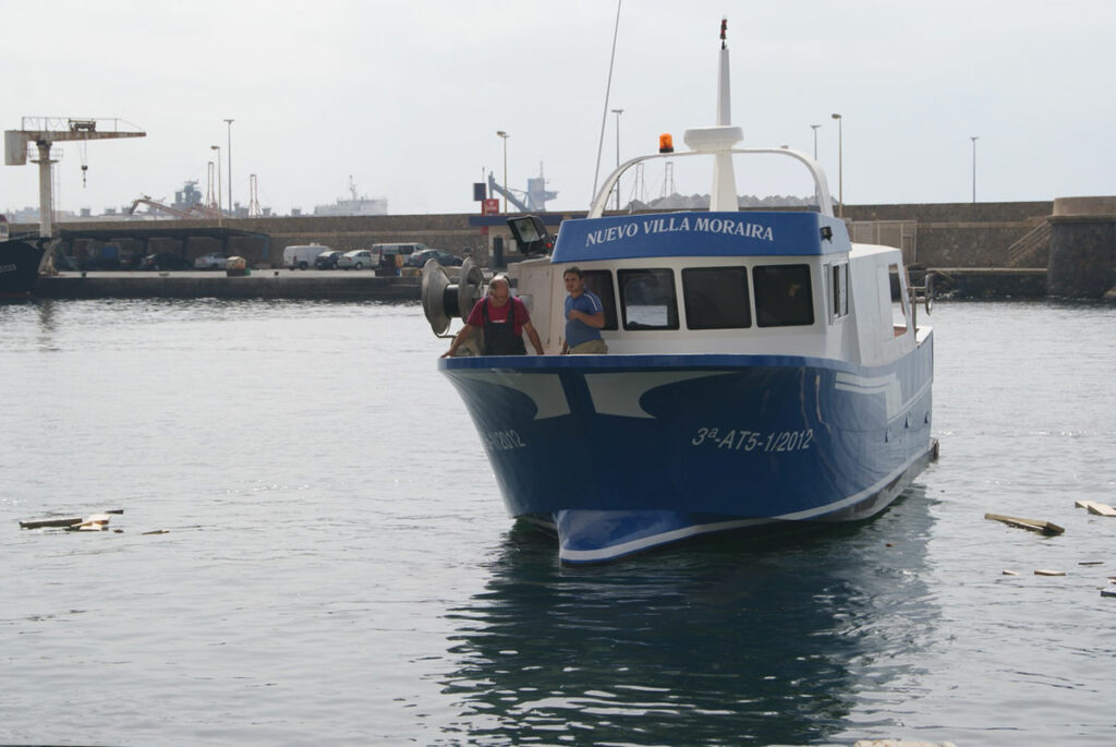 Barco pesquero Nuevo Villa Moraira accediendo a la rampa de Loha astilleros con dos tripulantes.