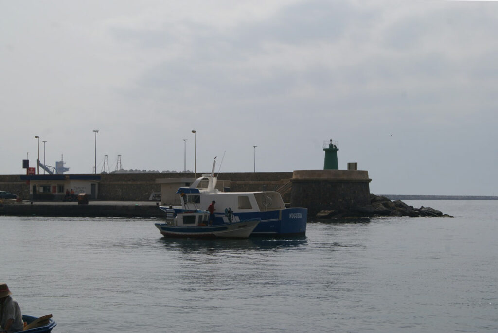 Barco pesquero Nuevo Villa Moraira navegando por el puerto marítimo junto a una pequeña embarcación.