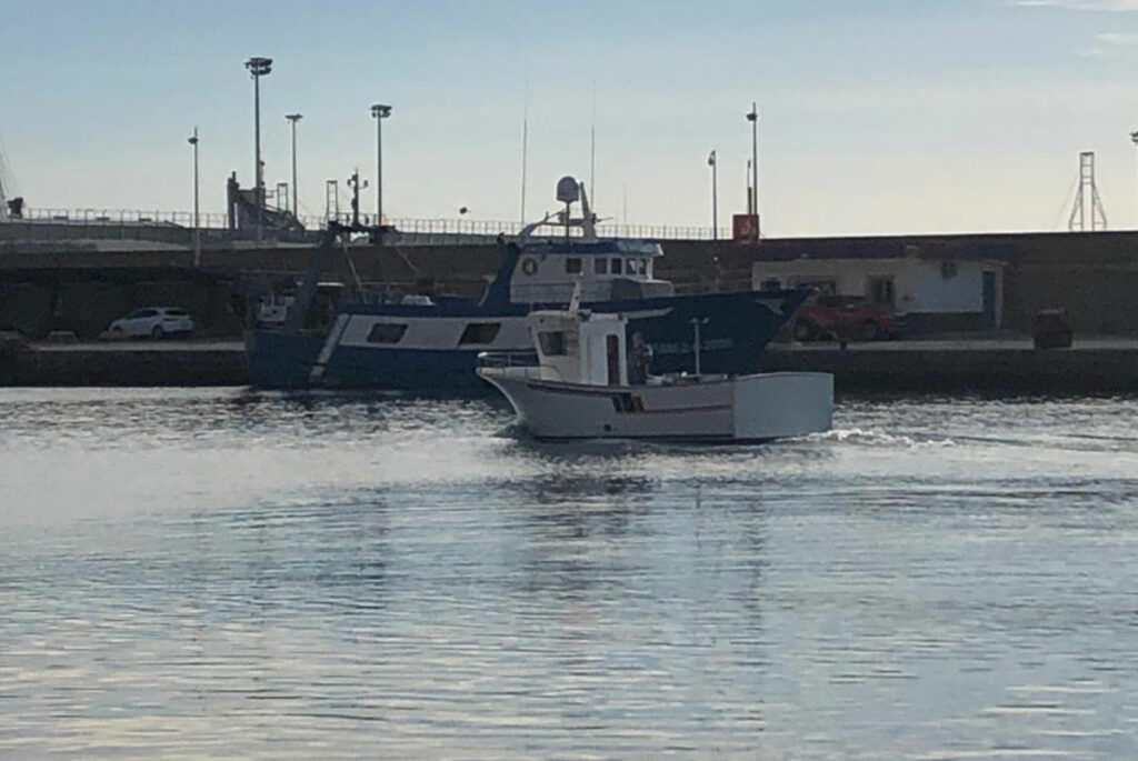 Barco de pesca Segundo Playa de Lancón navegando por el puerto marítimo.